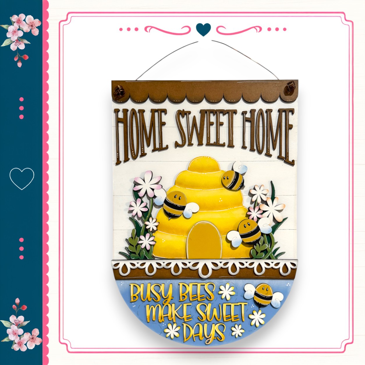 a decorative sign with a bee theme, displaying the text "HOME SWEET HOME" and "BUSY BEES MAKE SWEET DAYS" along with a bee illustration.