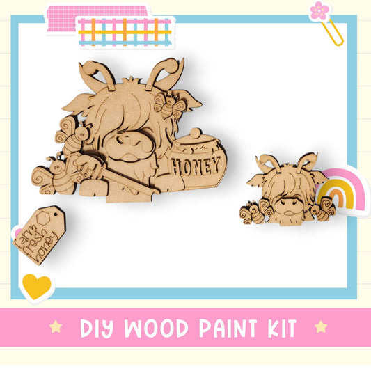 a wooden cutout of a cow with a rainbow in the background