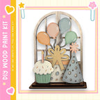 The image is a colorful and whimsical display featuring a cake, balloons, and a bow, all set against a pink and yellow background.