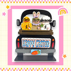A black truck with a wooden bed, decorated with Easter-themed stickers of a yellow chick, a white bunny, and a brown sheep. The truck has a sign that says "Happy Easter".