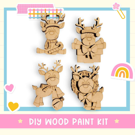 The image is a DIY wood paint kit featuring four wooden reindeer figures in various poses, including sitting, standing, and holding a bell.