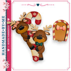 a pair of wooden reindeer with bows, a candy cane, and a small wooden door, all set against a white background.