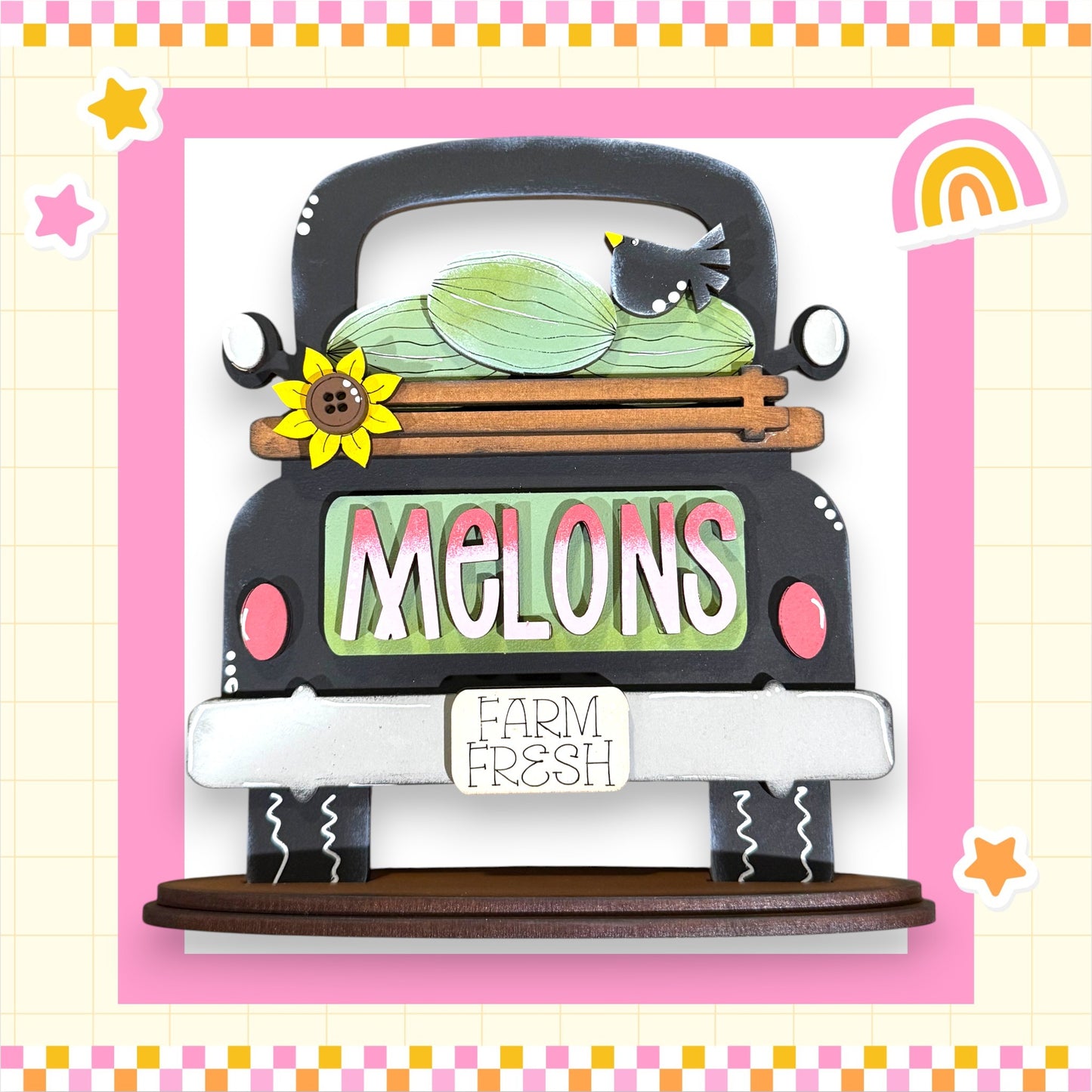 A wooden truck with a melon on the back, surrounded by a pink and white checkered border and a rainbow. The word "Melons" is displayed on the truck, and there is a sign that says "Farm Fresh".
