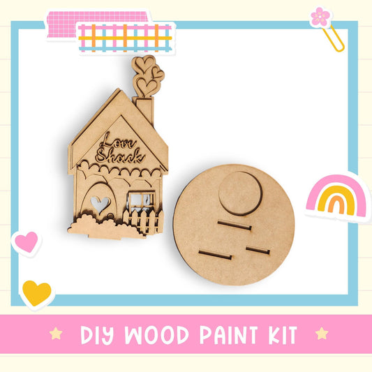 a DIY wood paint kit, including a wooden house-shaped ornament and a circular wooden tool or tray.