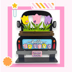 A colorful and whimsical truck decoration with a floral design and the text "Hello Spring" displayed on the back.