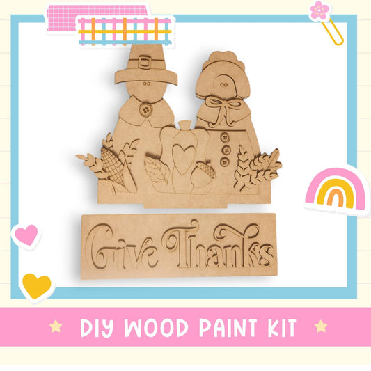 a wooden cutout of two people with a rainbow in the background