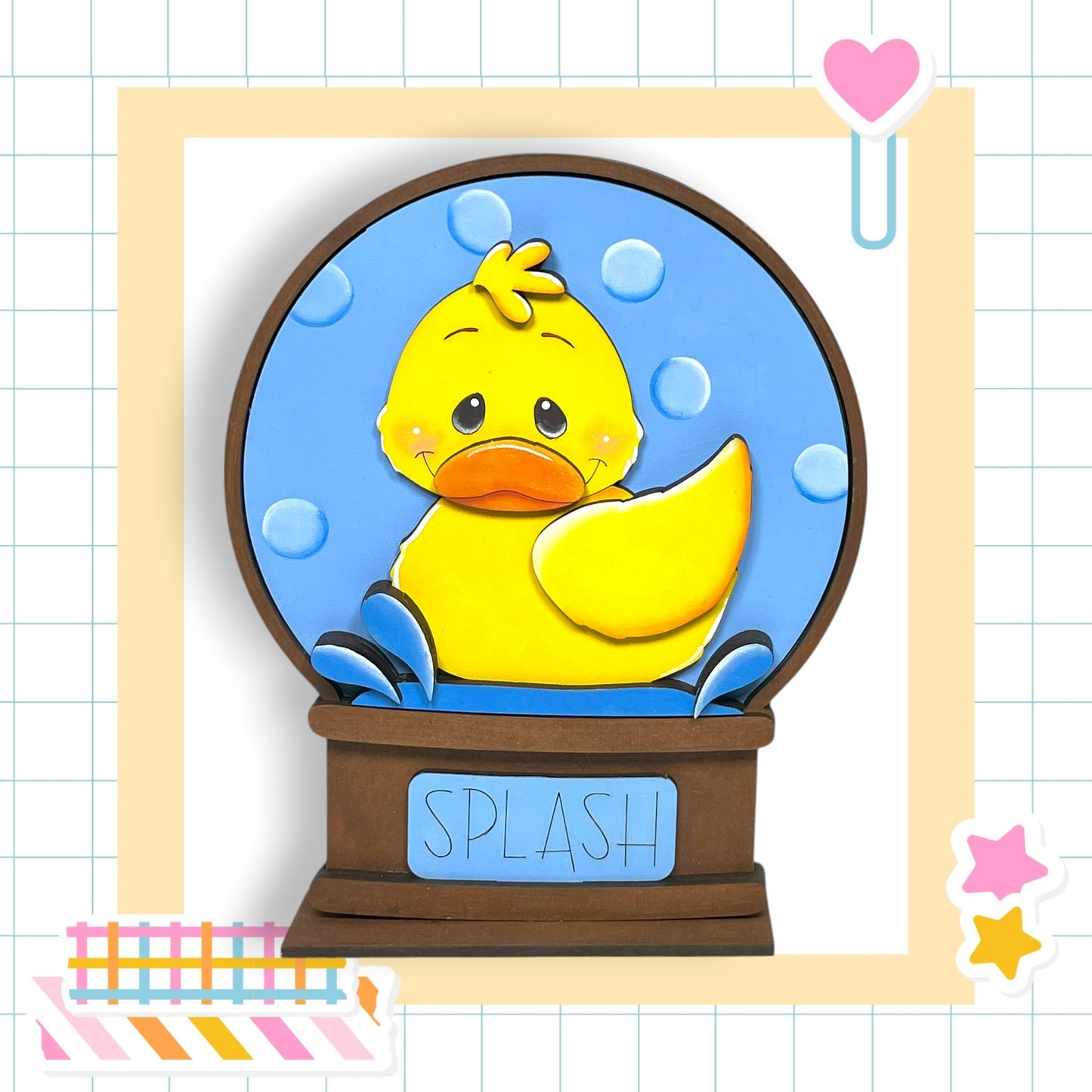 A yellow duck sitting inside a blue bubble-filled snow globe, with the word "SPLASH" written on the snow globe base.