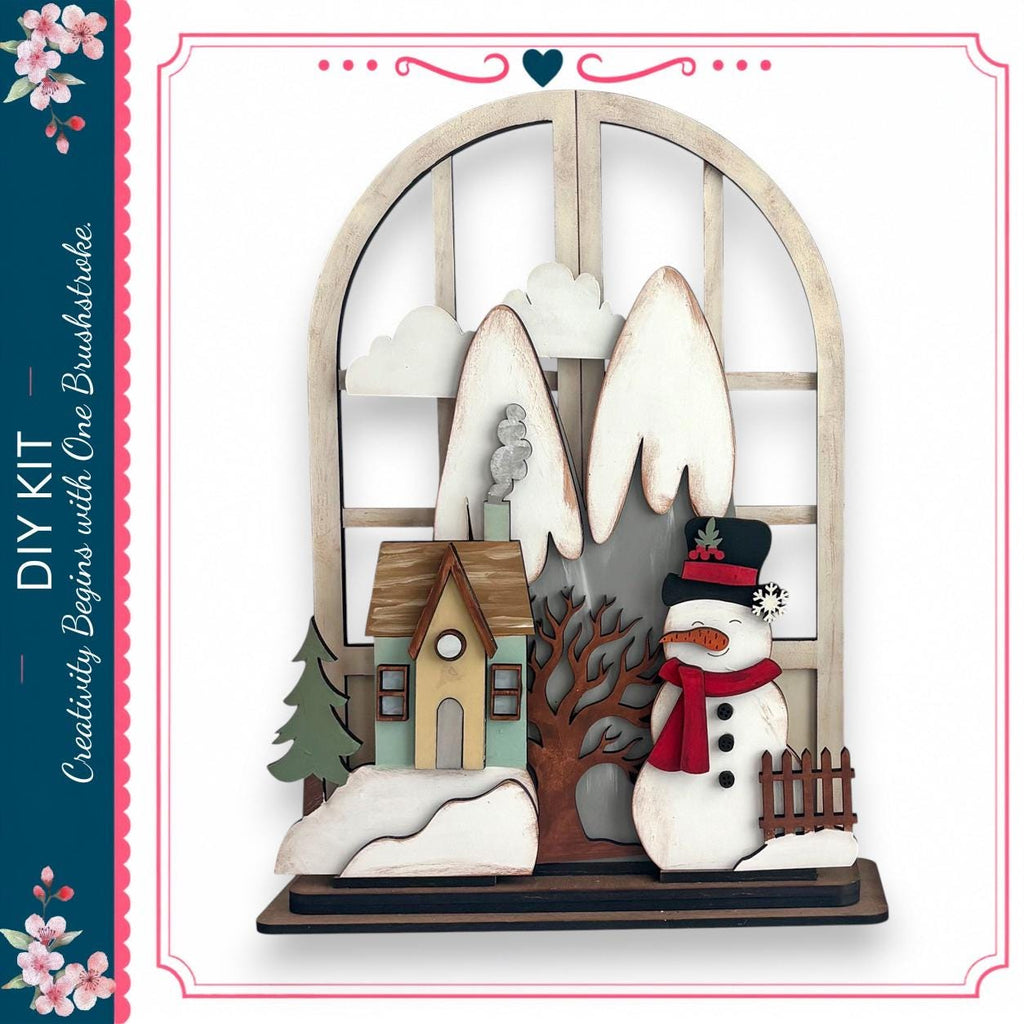 A wooden snowman stands in front of a window, with a small house and tree visible through the window.