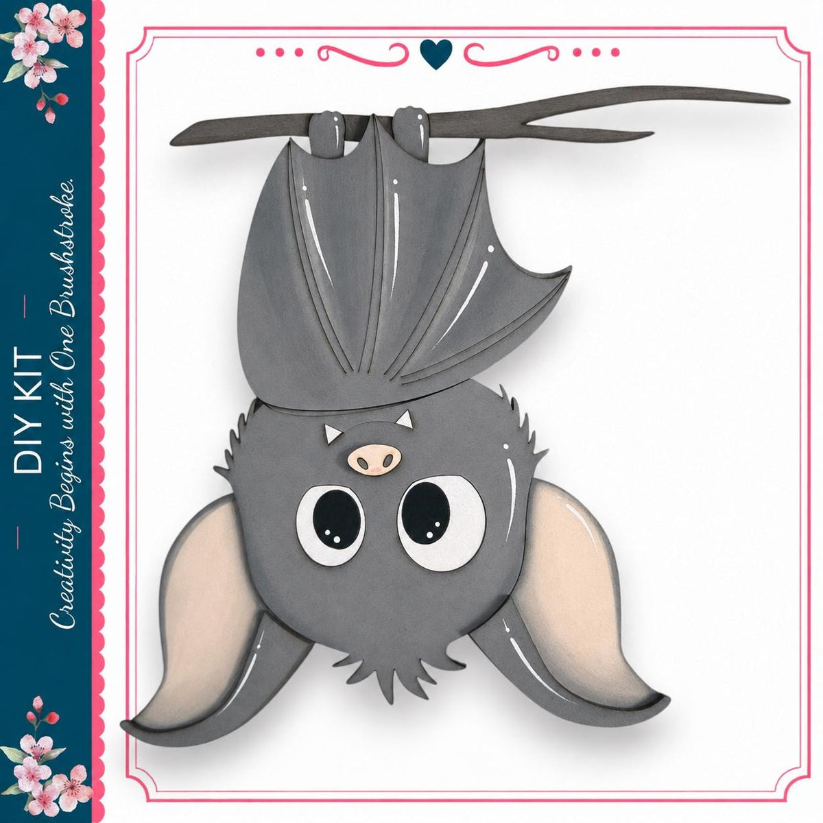 A cute gray bat with large eyes and a pink nose is hanging upside down from a branch, surrounded by a decorative border.