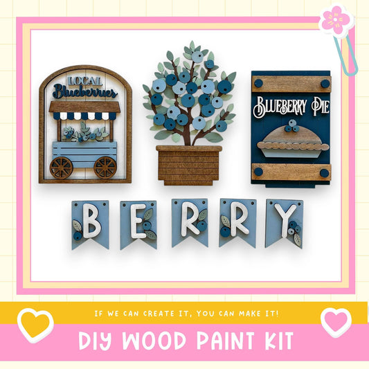 The image is a DIY wood paint kit featuring a "Local Blueberries" sign, a "Blueberry Pie" sign, and a "Berry" banner. The kit appears to be made of wood and is designed for creating custom signs or decorations.