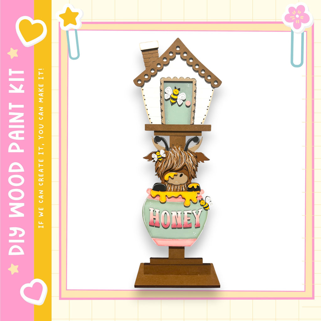 A wooden house-shaped object with a honey pot on top, featuring a cartoon character inside.