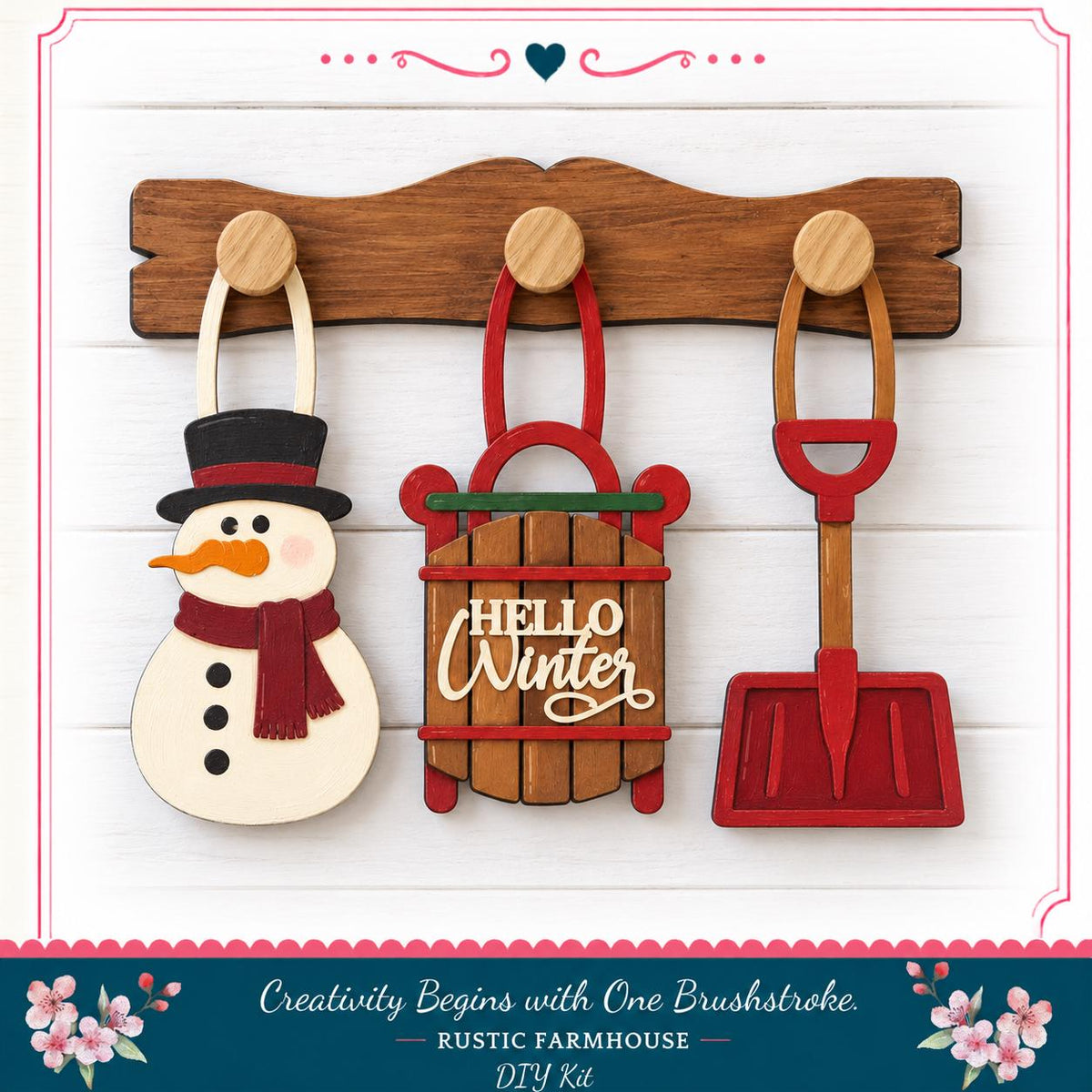 A wooden coat rack with three wooden ornaments hanging on it, including a snowman, a sled, and a shovel.