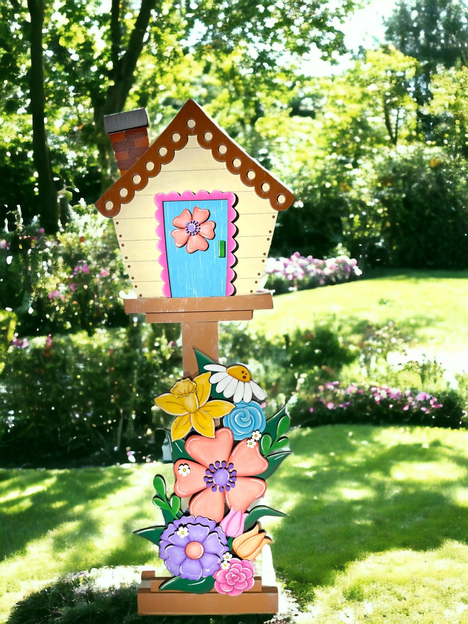 a bird house with flowers painted on it