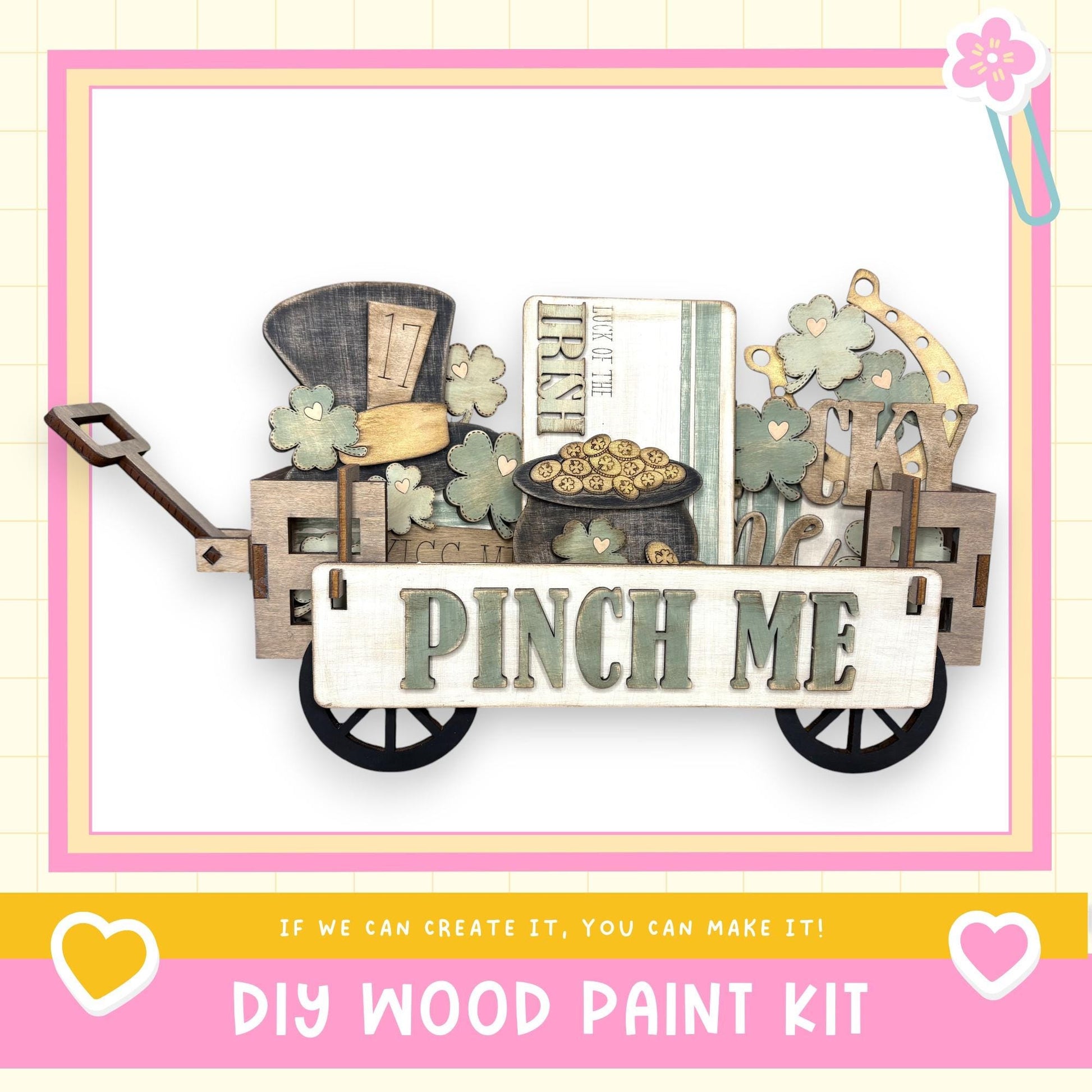 A wooden wagon with a sign that says "Pinch Me" and various other wooden objects, such as a hat, a book, and a clock, is displayed in the image.