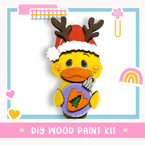 A cheerful cartoon duck wearing a Santa hat and holding a Christmas ornament, with the text "DIY WOOD PAINT KIT" below the image.