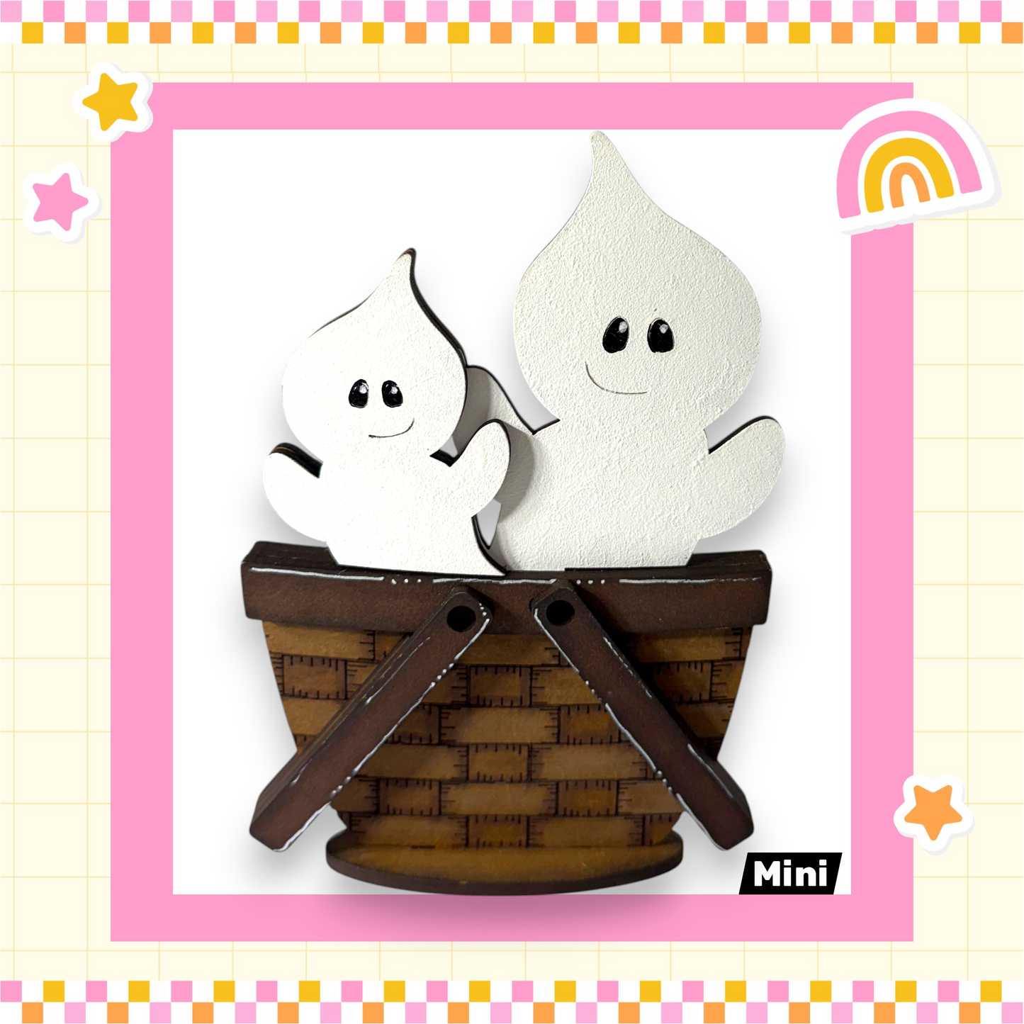 A wooden basket with two ghostly figures inside, set against a pink and yellow checkered background with stars and a rainbow.