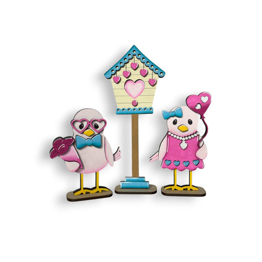 a couple of birds standing next to a birdhouse