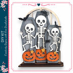 A Halloween-themed DIY kit featuring a skeleton graveyard with carved pumpkins and bats.