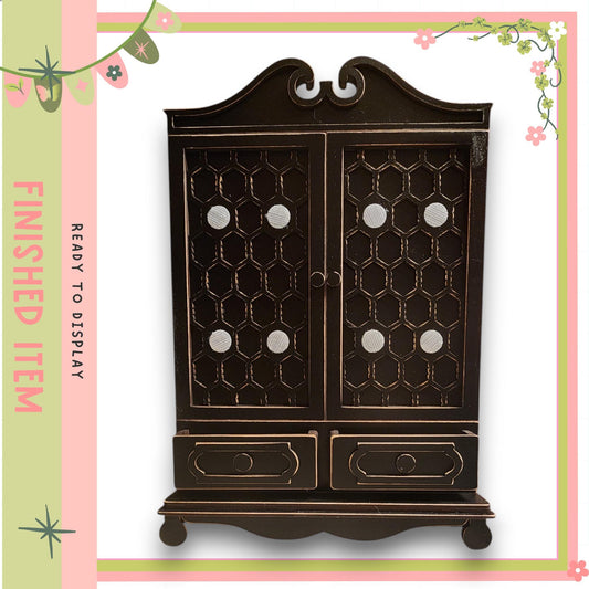a dark wooden cabinet with two doors and two drawers, set against a pink and green floral border.