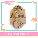 a wooden sign that says autumn with a rainbow in the background