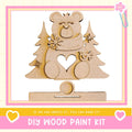 a DIY wood paint kit, with a wooden bear figure and pine trees as the main decorative elements.