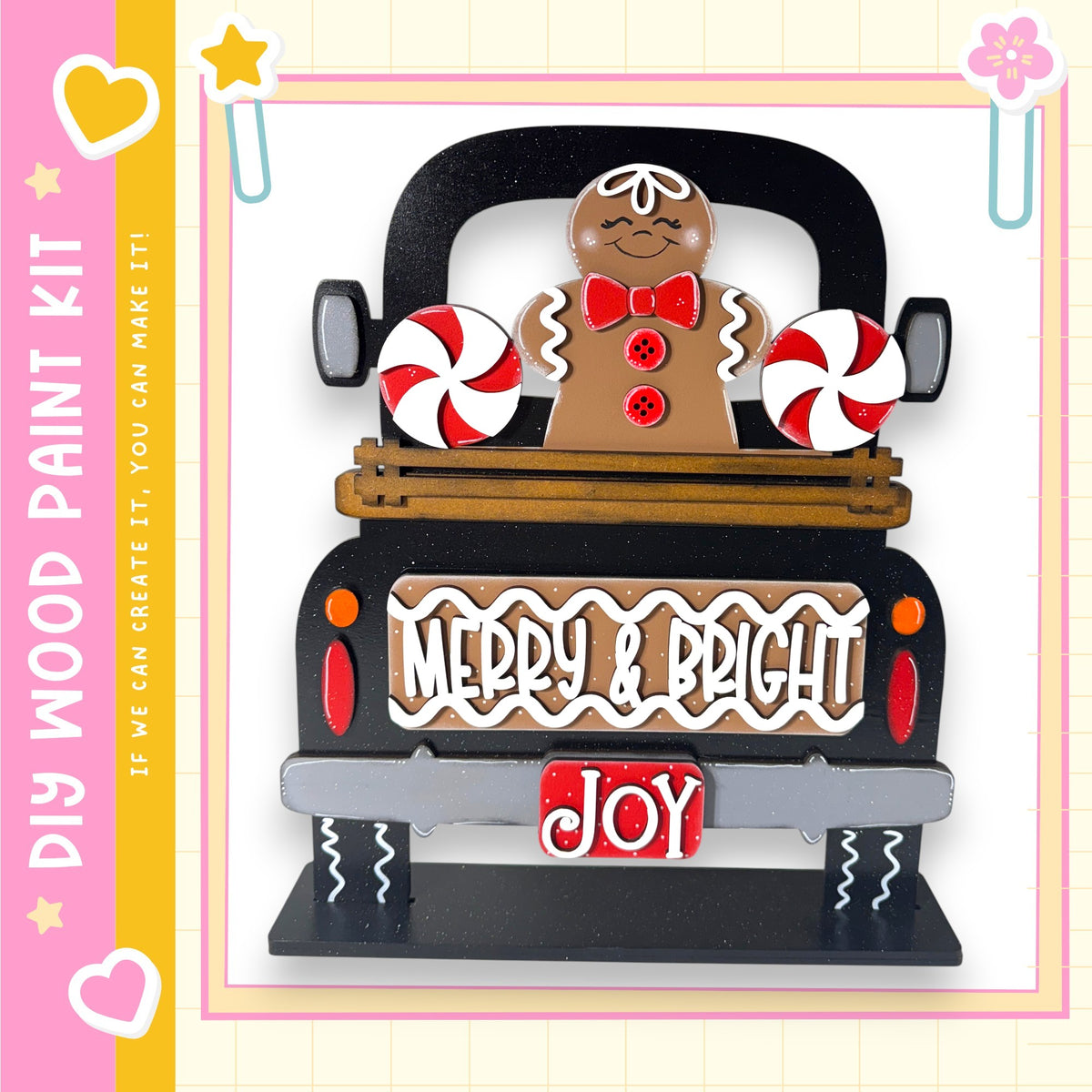 A black truck with a gingerbread man and candy decorations, including red and white striped candy canes, on the back.