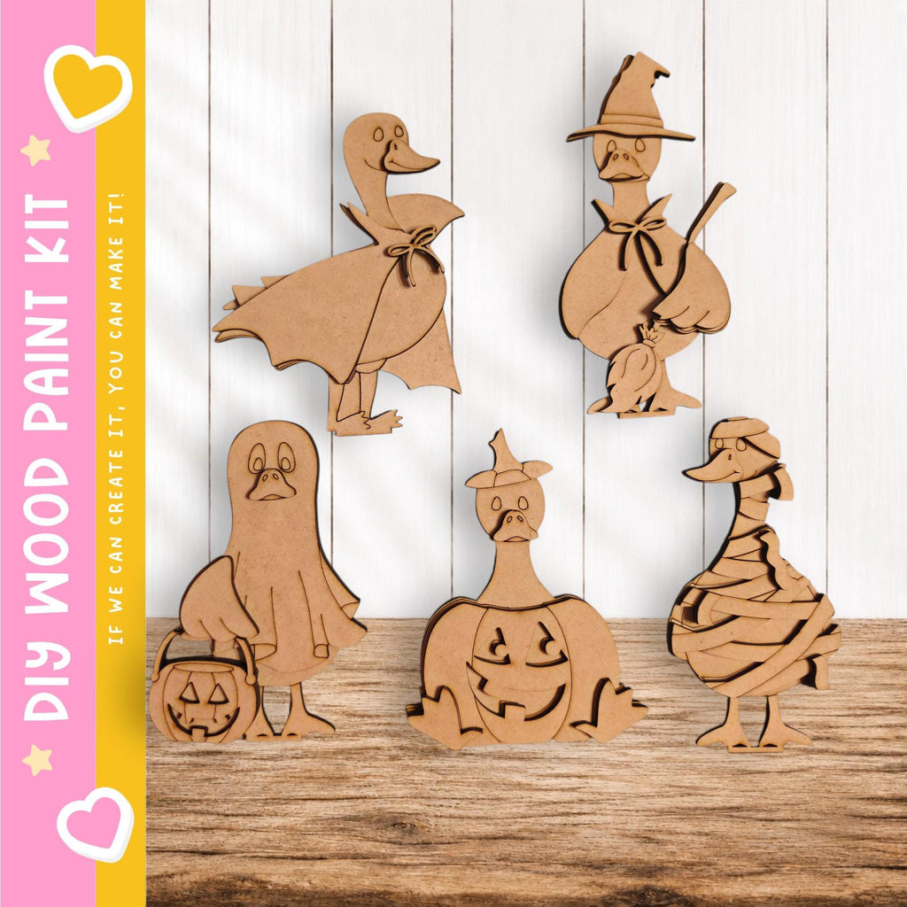 A collection of wooden cutouts depicting various Halloween-themed characters, including a witch, pumpkin, ghost, and duck.