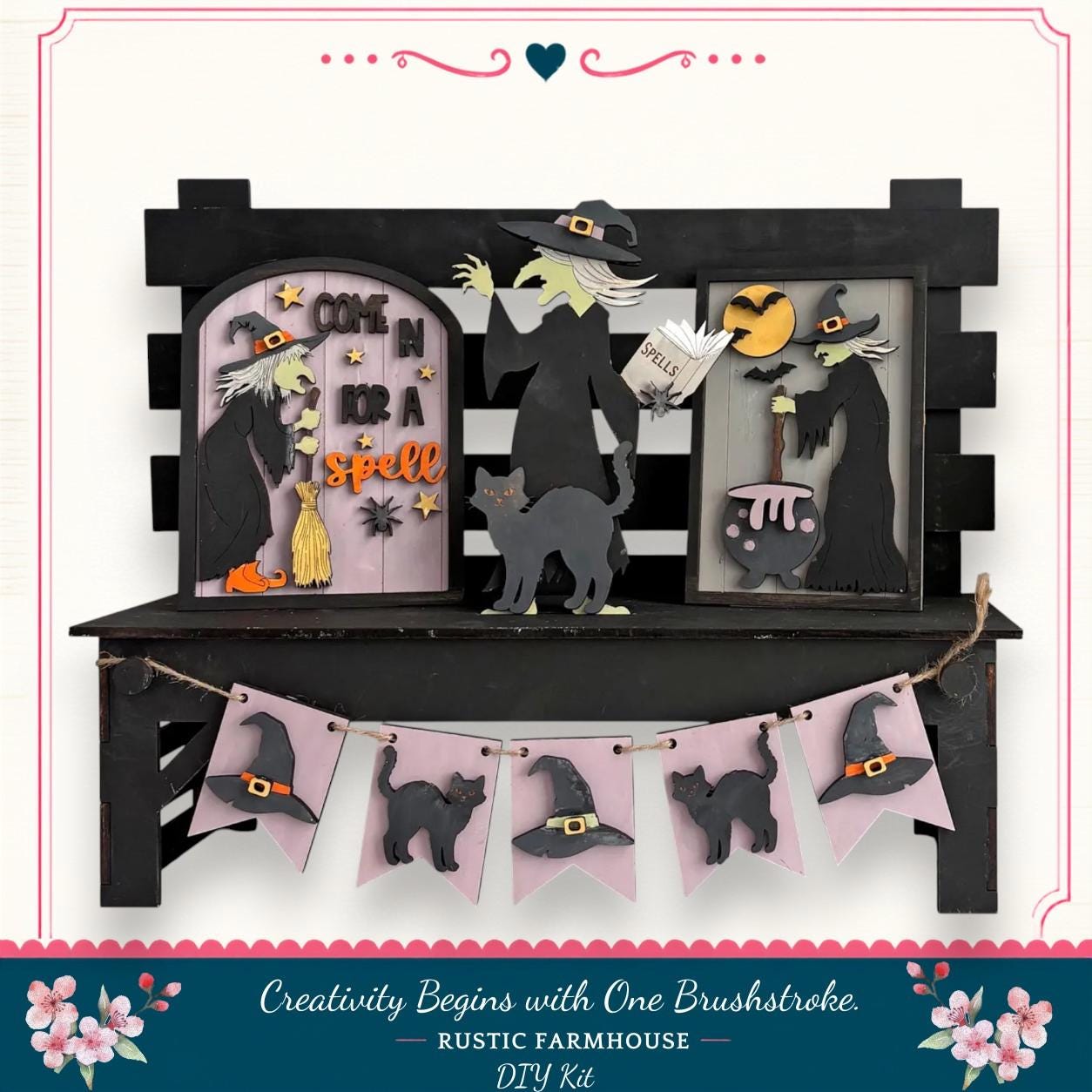 A Halloween-themed display featuring a black wooden bench with various Halloween-themed decorations, including a witch, a cat, and a cauldron. The display also includes a banner with black cat silhouettes and a "One Brushstroke" sign.