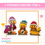 three rubber ducks wearing christmas hats and scarves
