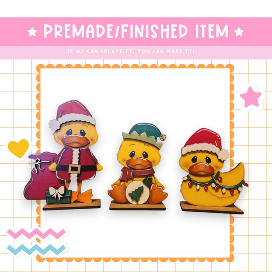 three rubber ducks wearing christmas hats and scarves