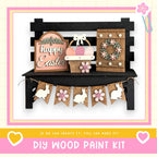 A DIY wood paint kit for creating Easter decorations, including a sign, a wreath, and a banner with wooden rabbits.