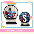 two wooden paint kits labeled "Fireworks & Freedom" and "USA", with various patriotic symbols and designs.
