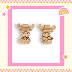 two wooden cartoon animal figures wearing festive hats, set against a pink and yellow checkered background with a rainbow and stars.