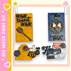 various wooden paint kit pieces, including a honeycomb, a bee, and a sign with the word "Honey".