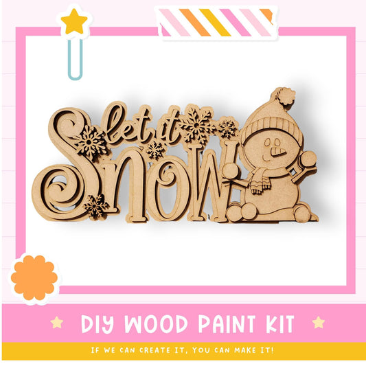 a DIY wood paint kit for creating a snowman, with a wooden snowman figure and the text "Let it Snow" prominently displayed.
