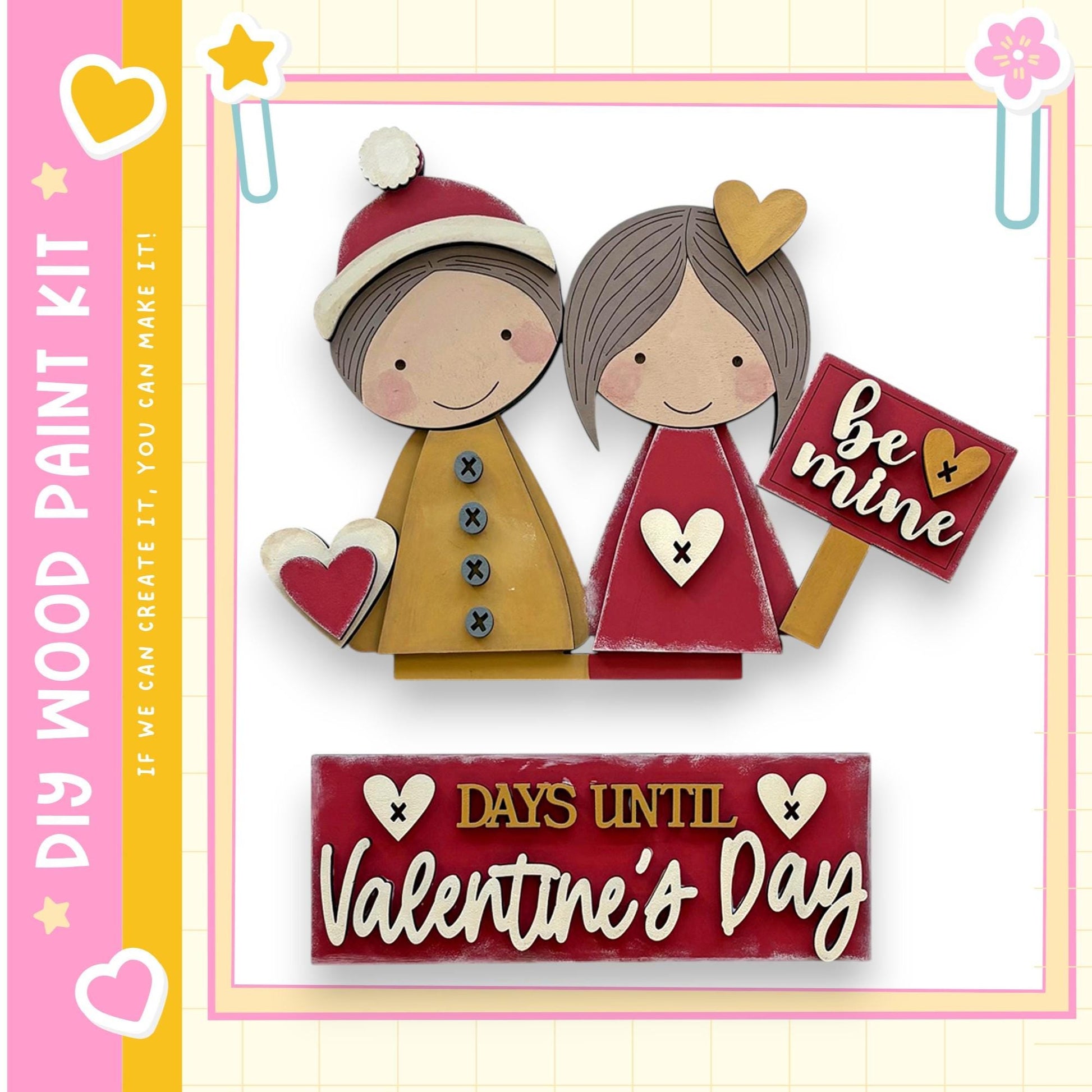 a wooden paint kit with two wooden figures, one male and one female, holding a sign that says "be mine". The kit is labeled as "DIY WOOD PAINT KIT" and "IF WE CAN CREATE IT, YOU CAN MAKE IT". The kit is set against a pink and yellow background, and there is a sign that reads "DAYS UNTIL Valentine's Day".