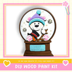 A wooden snow globe with a teddy bear wearing a winter hat and scarf, surrounded by snowflakes, and the text "Winter Wonderland" on the base.