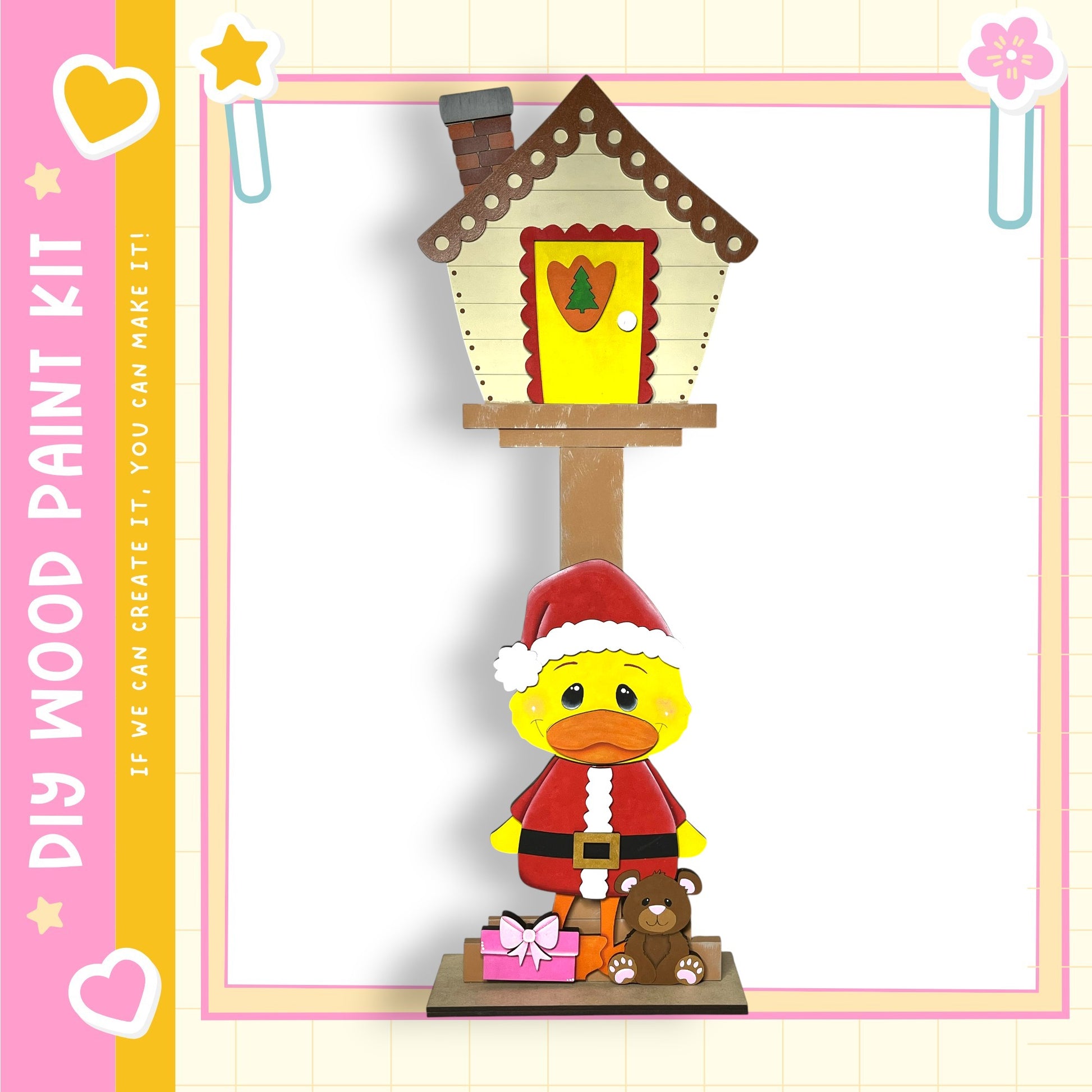 A wooden toy house with a yellow duck wearing a Santa Claus outfit, including a red hat, red scarf, and a red belt, standing on a wooden base.
