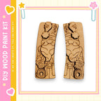 two wooden cutouts of a gnome holding a camera, set against a pink and yellow background with decorative elements.