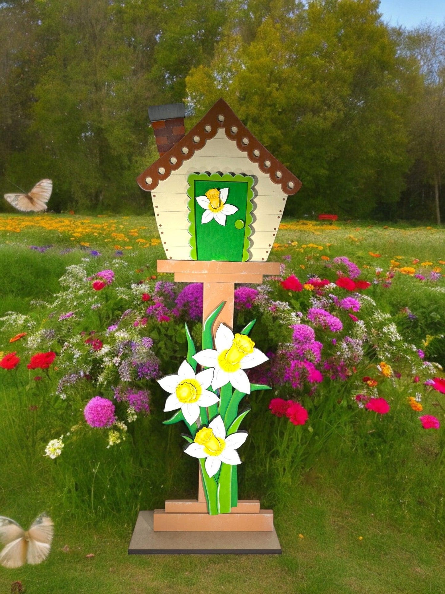 a garden with flowers and a bird house