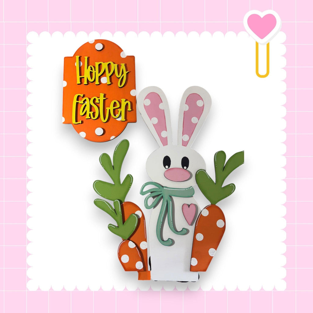 a paper cut out of a bunny holding carrots