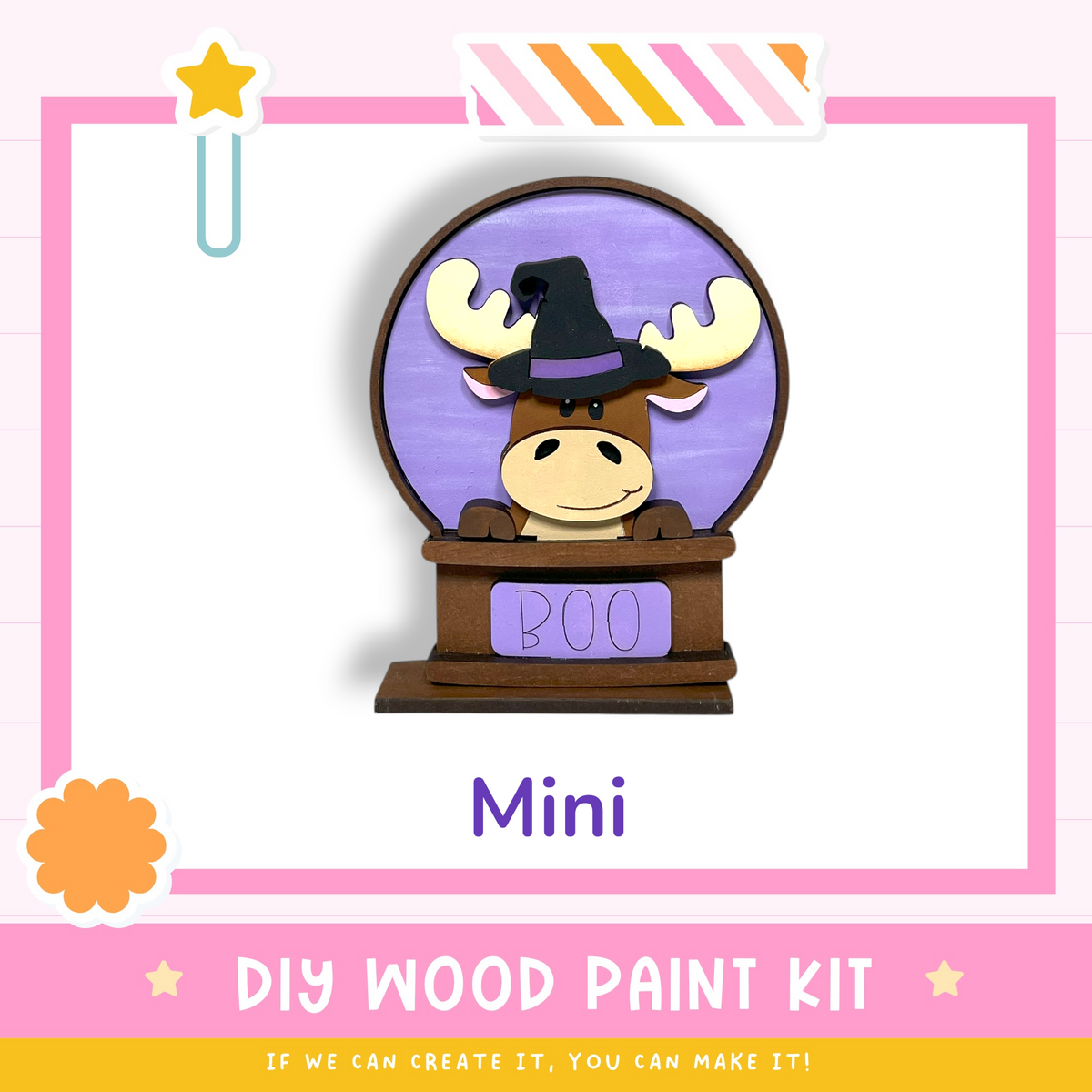 a wooden snow globe with a moose wearing a witch's hat, labeled "BOO" and "Mini". The background is pink and white, and there is a text box at the bottom that reads "DIY WOOD PAINT KIT" and "IF WE CAN CREATE IT, YOU CAN MAKE IT!"