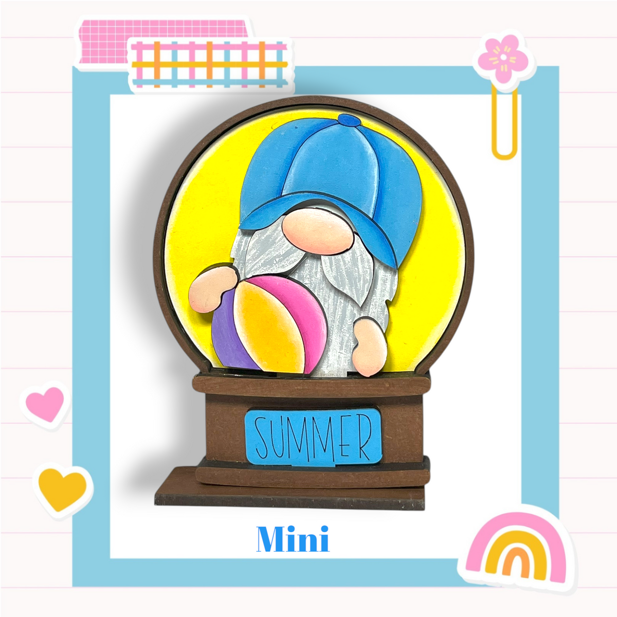 A gnome figurine wearing a blue hat and holding a beach ball, with the word "SUMMER" written on a sign below the gnome.