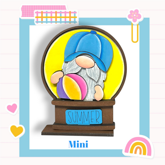 A gnome figurine wearing a blue hat and holding a beach ball, with the word "SUMMER" written on a sign below the gnome.