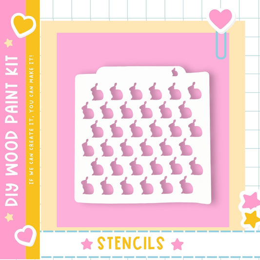 The image is a colorful and playful advertisement for a DIY paint kit featuring a white stencil with a pattern of pink hearts and stars.