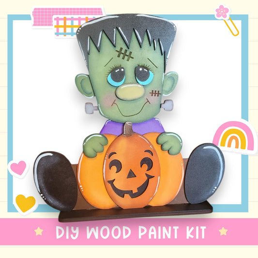 A DIY wood paint kit featuring a carved pumpkin and a green monster character with a carved face.