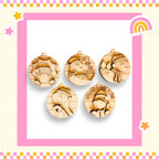 five wooden ornaments with various designs, including a cat, a dog, and a bird, all set against a pink and yellow checkered background.
