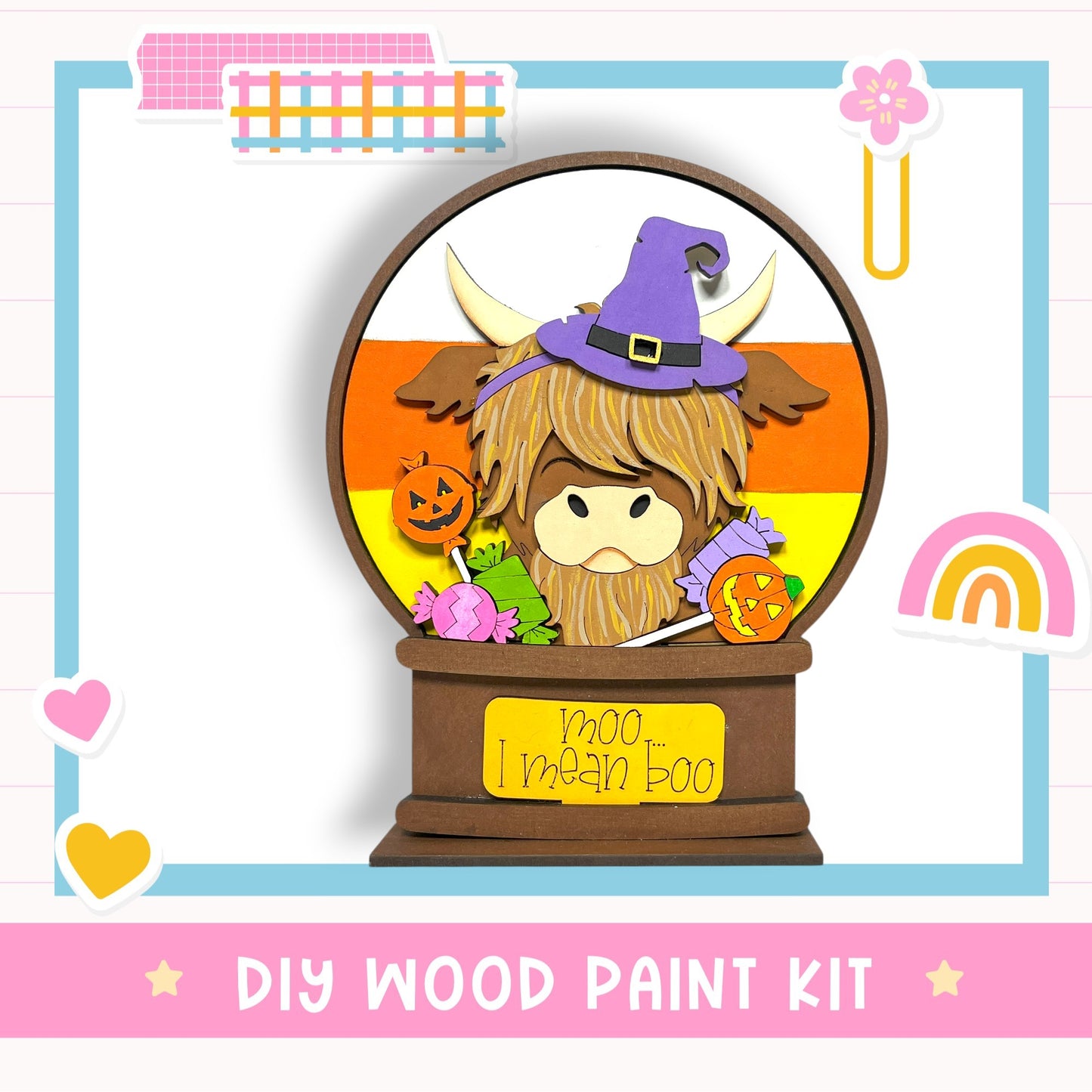 A wooden paint kit featuring a whimsical design of a cow wearing a witch's hat and surrounded by Halloween-themed elements, such as a pumpkin and a rainbow.
