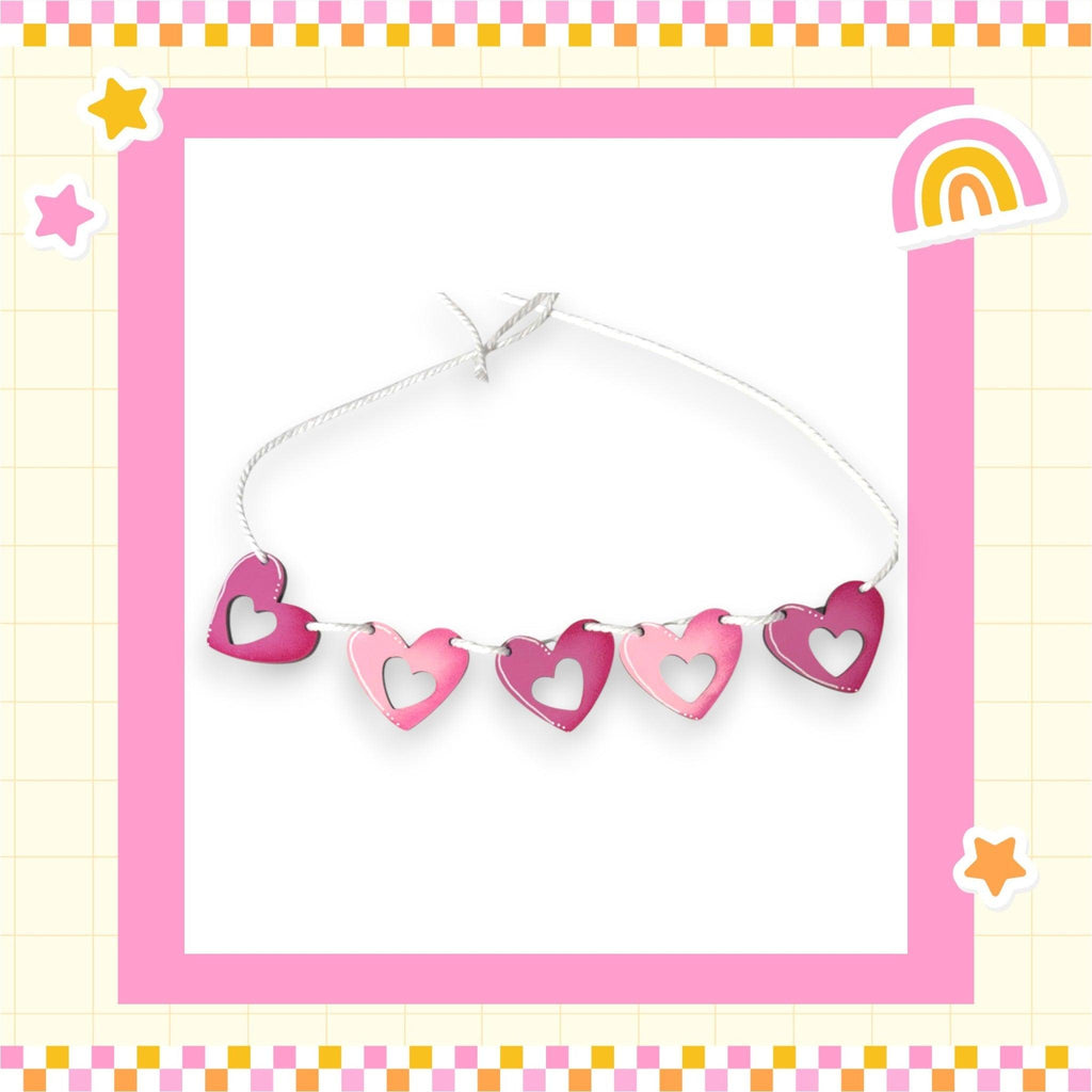 a picture of a string of hearts with a rainbow in the background