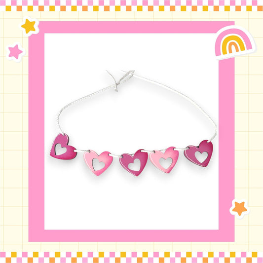 a picture of a string of hearts with a rainbow in the background